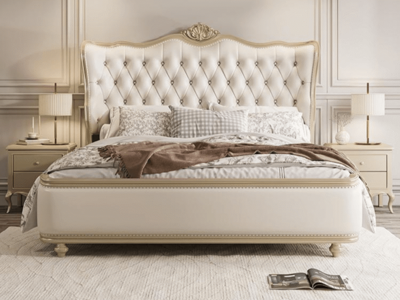 Giường ngủ tân cổ điển GI2803-18 màu kem, đặt chính diện trong phòng ngủ sang trọng với tường ốp phào chỉ trắng, hai đèn n…