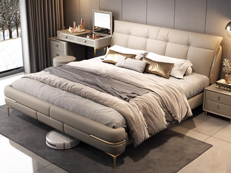 Giường ngủ bọc da cao cấp GI5361-18 được chụp từ góc chếch, cho thấy tổng thể giường với đầu giường bọc da màu be có các đ…