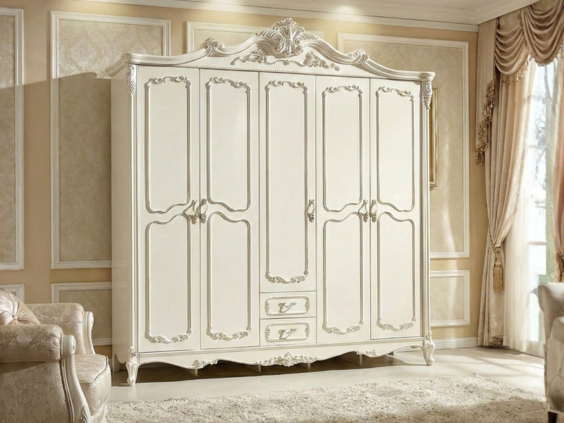 Tủ quần áo 5 cánh tân cổ điển màu trắng ngọc trai, chụp chính diện trong phòng ngủ sáng sủa. Tủ có các đường phào chỉ và h…