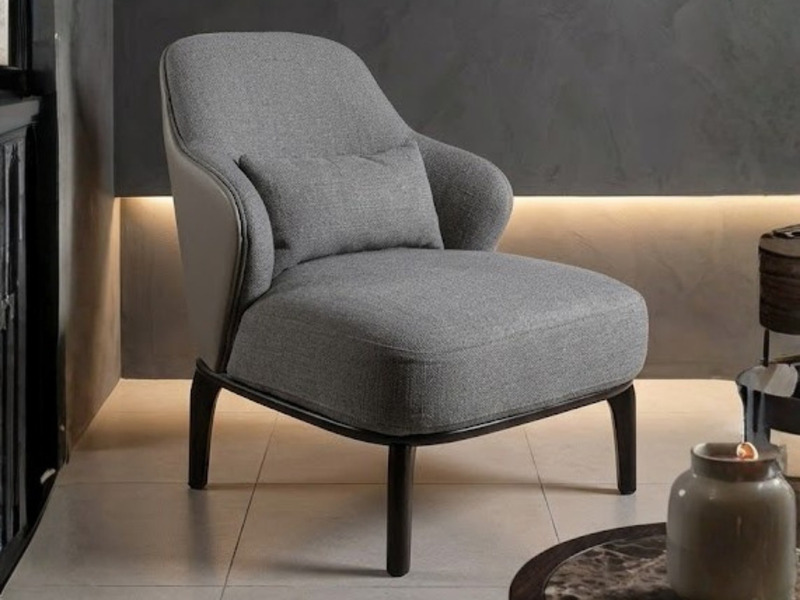 Ghế thư giãn Y31 được chụp nghiêng từ phía trước bên trái, đặt trong một không gian phòng khách sang trọng với tông màu tố…