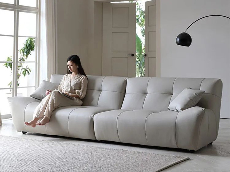 Sofa băng SFA31-4 màu be sáng, bọc da bò tự nhiên, chụp ngang trong phòng khách hiện đại. Thiết kế tối giản với múi đệm vu…