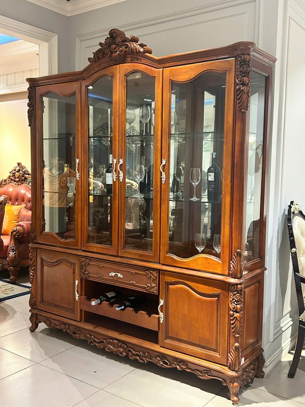 Tủ rượu 4 cánh TR1701-4 chụp góc nghiêng từ bên phải, làm nổi bật đường nét chạm khắc tinh xảo ở phần đỉnh và các cột trụ…