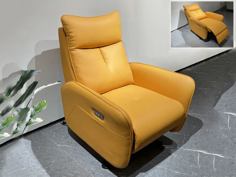 Ghế thư giãn điện E63 màu vàng cam nổi bật, chụp từ góc hơi cao, đặt trên sàn gạch xám đậm. Ghế có thiết kế hiện đại với n…