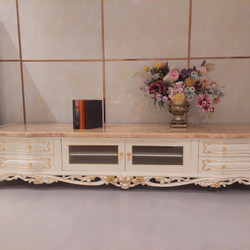 Kệ tivi tân cổ điển KT622-24 màu trắng ngọc trai với mặt đá hồng ngọc long nhân tạo, được chụp chính diện trong không gian…