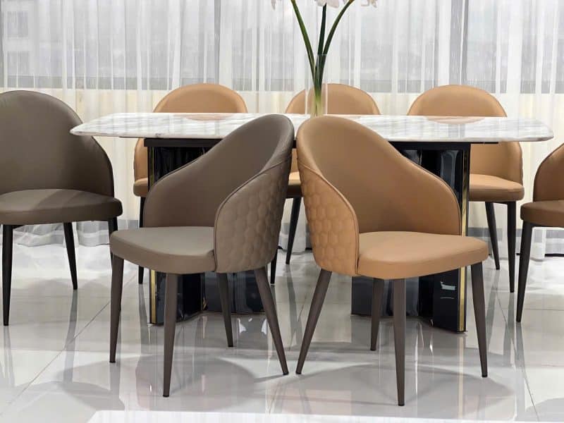 Hai ghế ăn hiện đại GA479 được đặt đối diện nhau quanh một bàn ăn mặt đá màu trắng vân mây, chân bàn màu đen. Ghế có lưng…