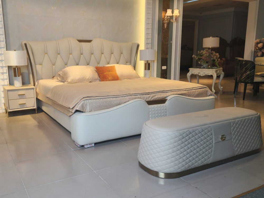 Giường ngủ bọc da luxury GI2336-20 và ghế băng cuối giường, chụp góc nghiêng từ phía trước bên phải. Giường có đầu giường…