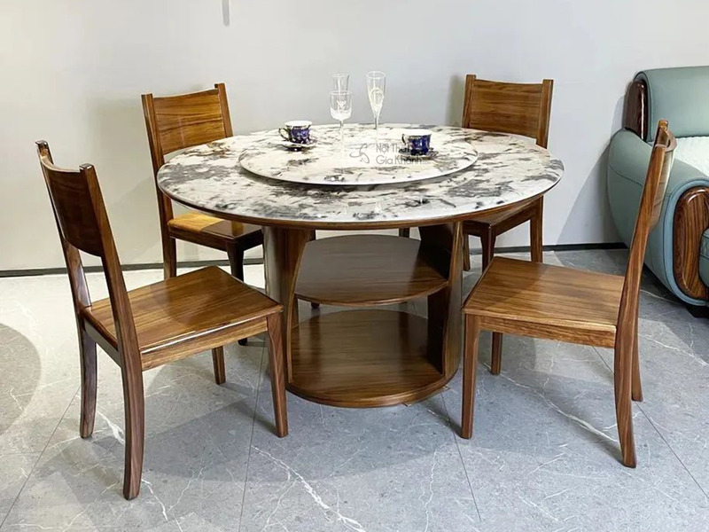 Bộ bàn ăn tròn hiện đại BAT110-135 chụp từ góc chếch, nổi bật mặt bàn đá siêu pha lê vân xám trắng với mâm xoay. Chân bàn…
