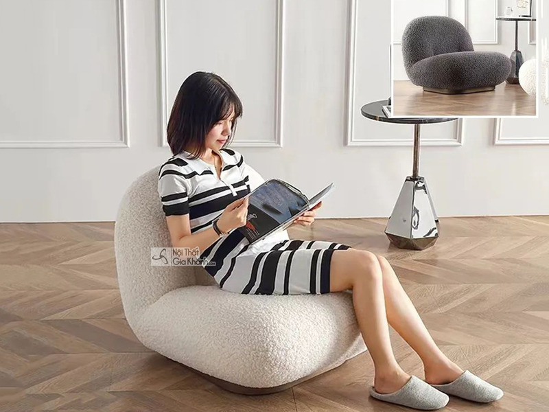 Một phụ nữ trẻ đang ngồi thư giãn trên ghế GTE38 màu trắng kem, đọc sách. Ghế có kiểu dáng hiện đại, bọc vải giả len mềm m…