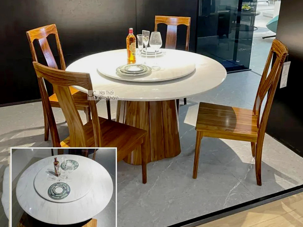 Ảnh chụp tổng thể bộ bàn ăn tròn gỗ Mun hiện đại BAT106-130 từ góc hơi chếch, đặt trong không gian showroom. Bàn có mặt đá…