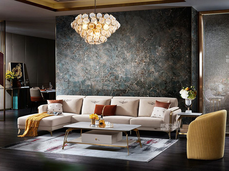 Bộ sofa góc phải 3 băng SBQ71-3 màu kem bọc da Nappa, nổi bật với chân viền thép không gỉ mảnh mai, đặt trong phòng khách…
