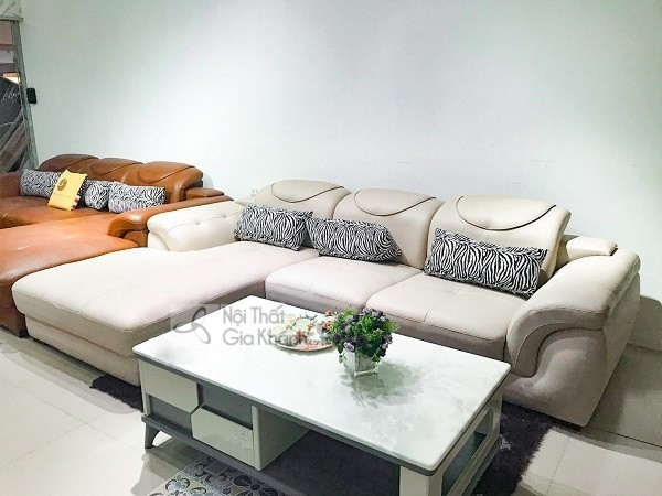 Sofa góc màu trắng kem có phần chaise, gối tựa họa tiết vằn