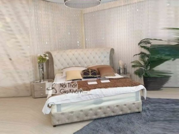 Giường ngủ chân thấp bọc da màu kem, đầu giường chần nút cao, kê cạnh tủ đầu giường