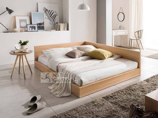 Giường ngủ thấp khung gỗ sáng màu, thành đầu giường kéo dài hai bên