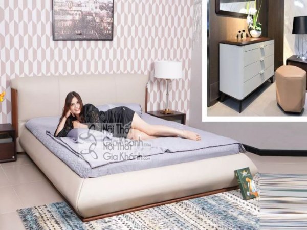 Giường ngủ thấp bọc da màu kem, đế gỗ sẫm, kê cạnh tủ đầu giường màu trắng