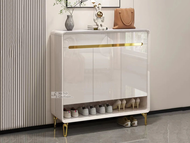 Tủ giày TDB502 màu trắng bóng, được chụp chính diện trong không gian tiền sảnh hiện đại. Tủ có thiết kế tối giản với hai c…