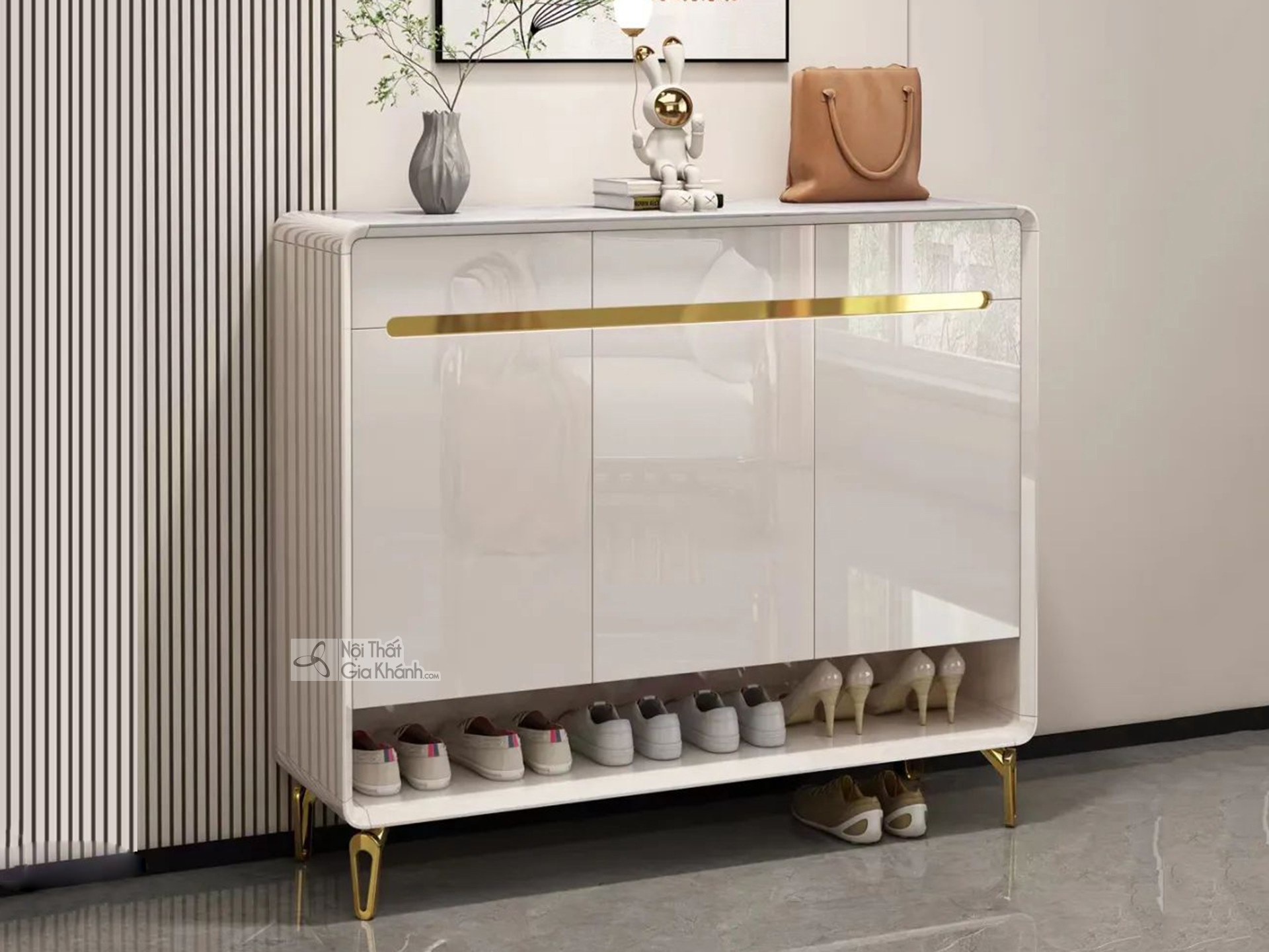 Tủ giày gỗ màu trắng TDB503 được chụp chính diện, đặt trong không gian tiền sảnh hoặc lối vào nhà. Tủ có bề mặt sơn bóng m…