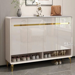 Tủ giày TDB504 màu trắng bóng, phong cách hiện đại, đặt trong không gian tiền sảnh. Tủ có mặt trên bằng đá vân xám, ba cán…