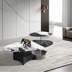 Bàn trà đôi BT2567A được chụp từ góc hơi chếch, đặt trên thảm trải sàn màu xám nhạt trong phòng khách hiện đại. Bàn chính…