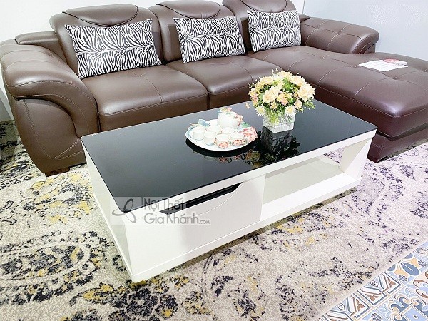 Bàn trà mặt kính đặt cạnh ghế sofa cao cấp trong phòng khách hiện đại