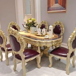 Bộ bàn ăn tân cổ điển gồm bàn hình oval và sáu ghế, chụp từ góc hơi chếch, tập trung vào chi tiết tinh xảo của khung bàn v…