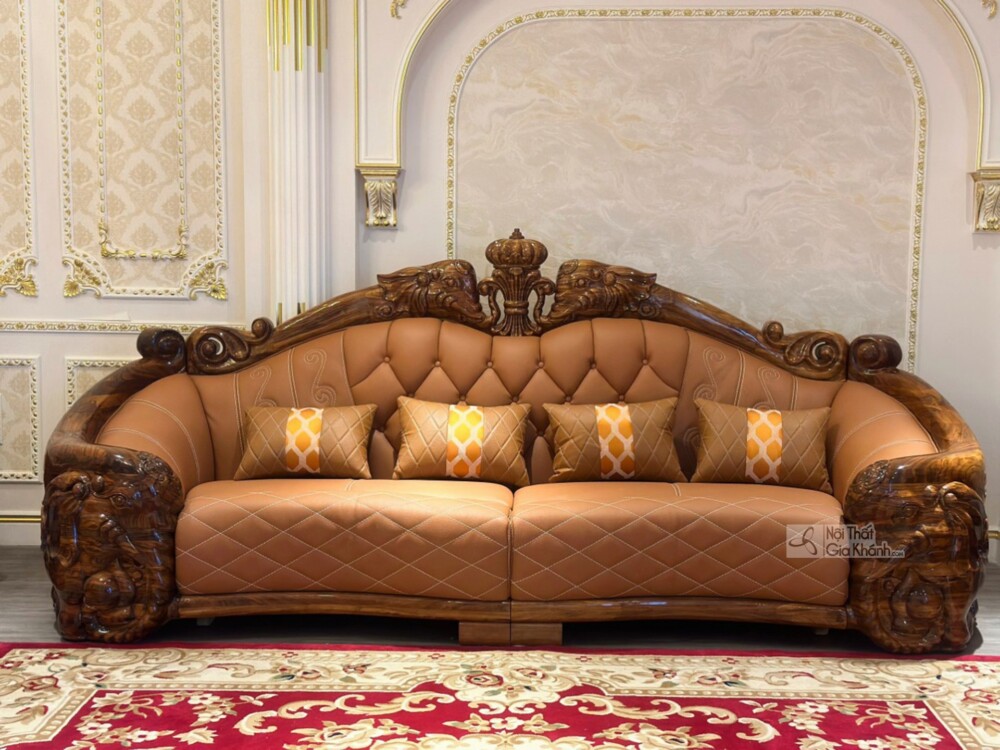 Cận cảnh ghế sofa băng dài của bộ SF808-1124, với khung gỗ mun tự nhiên chạm khắc tinh xảo hình đầu sư tử và vương miện. Đ…