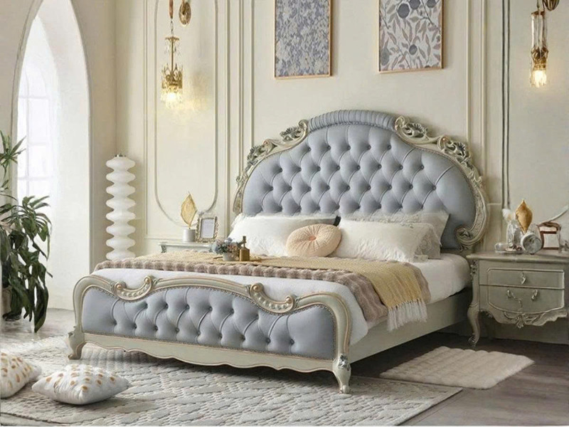 Giường ngủ tân cổ điển GI9022-18 chụp góc nghiêng, nổi bật đầu giường và thành giường bọc da màu xám xanh với nút rút. Khu…