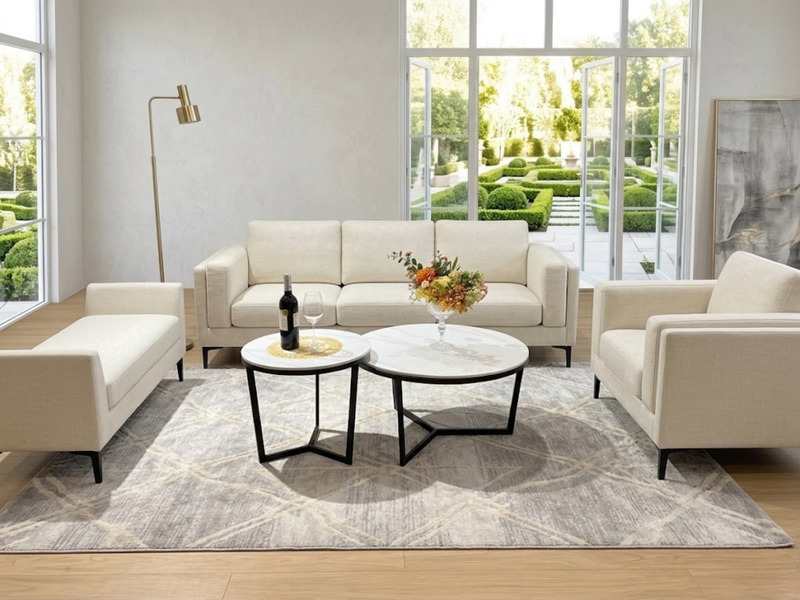 Tổng thể không gian phòng khách hiện đại với bộ bàn trà đôi chân Y cao đặt giữa bộ sofa màu kem. Hai bàn tròn mặt đá trắng…