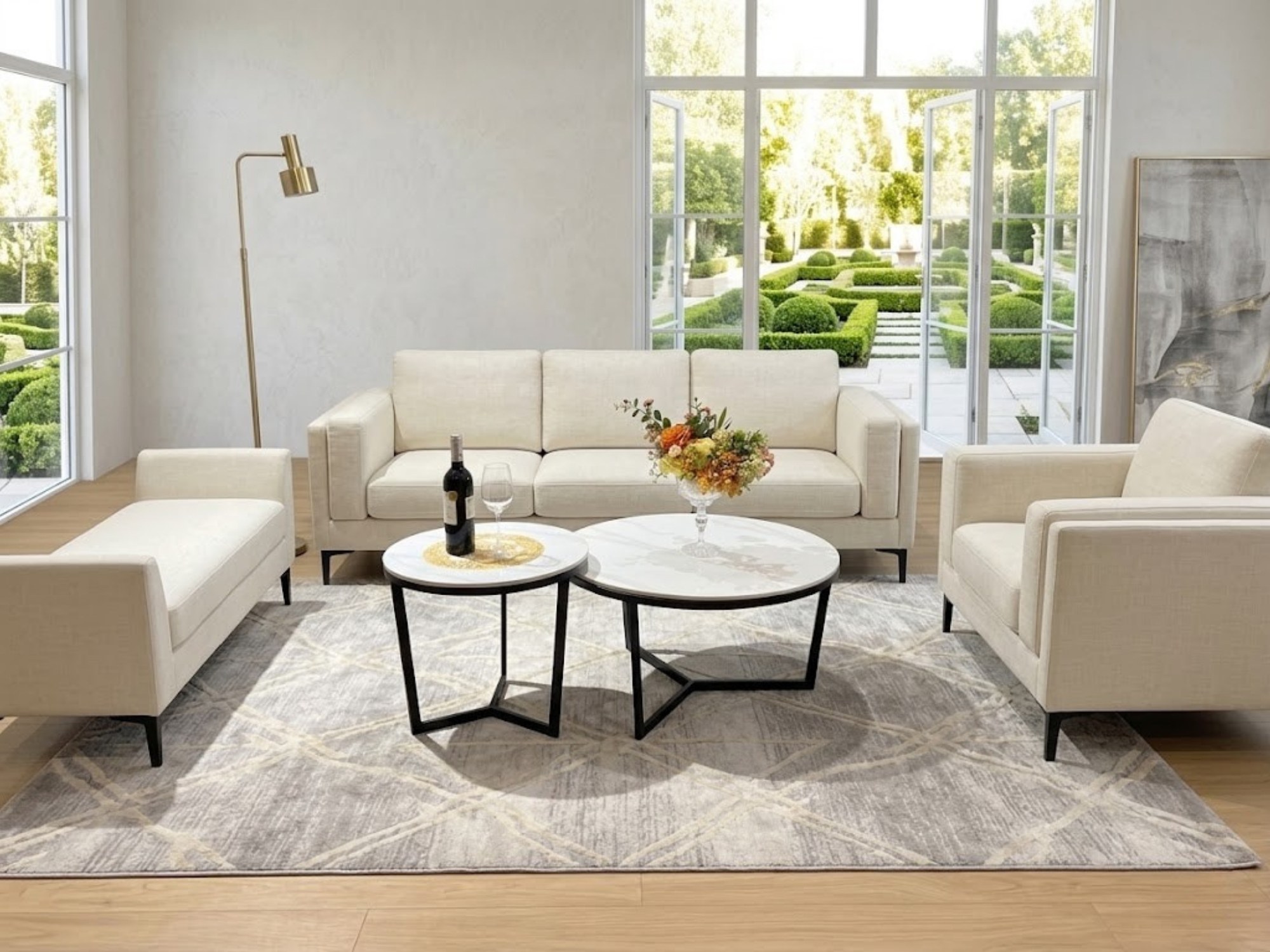Tổng thể không gian phòng khách hiện đại với bộ bàn trà đôi chân Y cao đặt giữa bộ sofa màu kem. Hai bàn tròn mặt đá trắng…