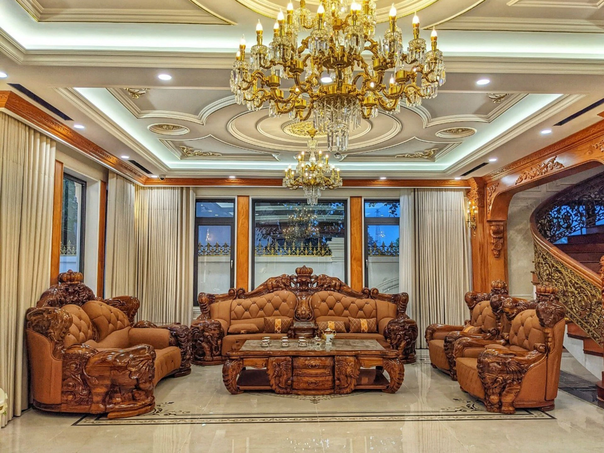 Bộ sofa gỗ mun tân cổ điển GK05-1124 được chụp toàn cảnh từ phía trước, hơi chếch sang phải, trong không gian phòng khách…