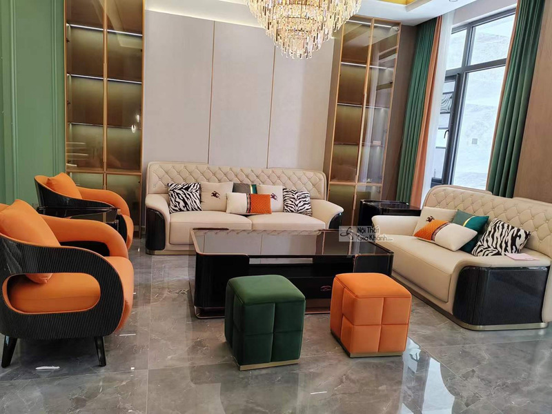 Toàn cảnh bộ sofa luxury SFQ626-1123 được sắp đặt trong phòng khách hiện đại, chụp từ góc chính diện. Hai ghế đơn màu cam…