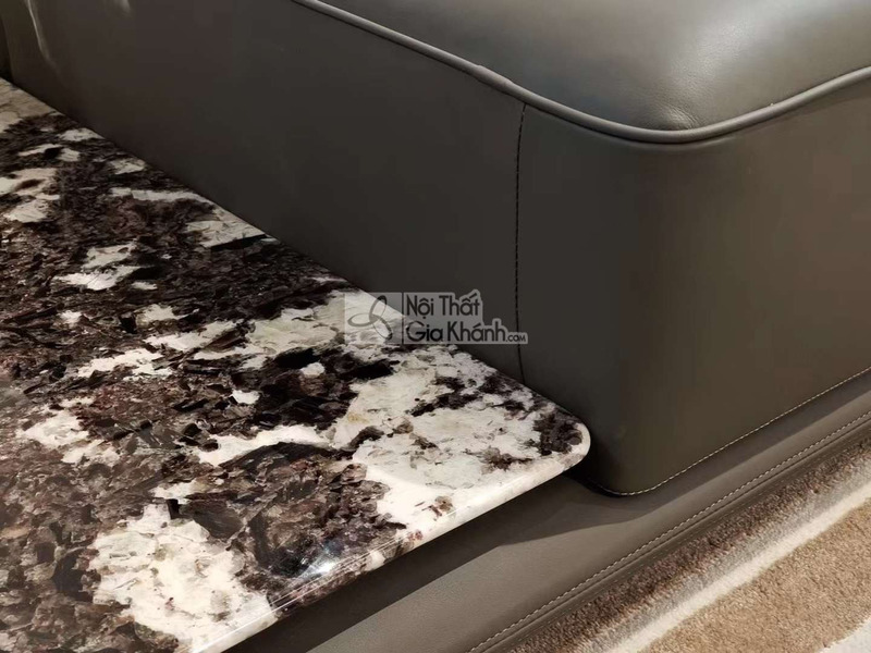 Chi tiết góc sofa SF2202 và mặt bàn trà liền kề, cho thấy rõ chất liệu da bò tự nhiên màu xám đậm với đường may tinh tế, t…