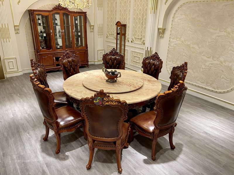 Bộ bàn ăn tròn 8 ghế phong cách tân cổ điển, chụp từ góc hơi cao, cho thấy tổng thể bàn mặt đá Hồng Ngọc Long nhân tạo với…