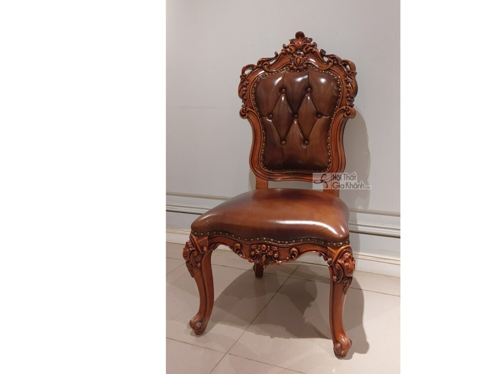 Một ghế ăn tân cổ điển GAC100-TN chụp chính diện trong không gian nội thất với tường màu sáng và sàn gạch men. Ghế có lưng…
