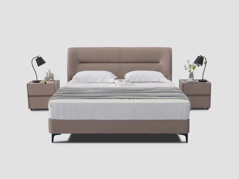 Giường ngủ bọc da hiện đại GIBJ086-18 được chụp chính diện trên nền xám nhạt. Giường có đầu giường cao, bọc da màu nâu be…