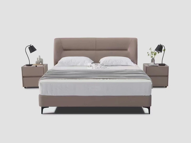 Giường ngủ bọc da hiện đại GIBJ086-18 được chụp chính diện trên nền xám nhạt. Giường có đầu giường cao, bọc da màu nâu be…