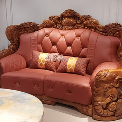 Cận cảnh băng sofa hai chỗ ngồi màu nâu đỏ, bọc da bò tót cao cấp, với khung gỗ mun Nam Phi được chạm khắc hoa văn cầu kỳ…