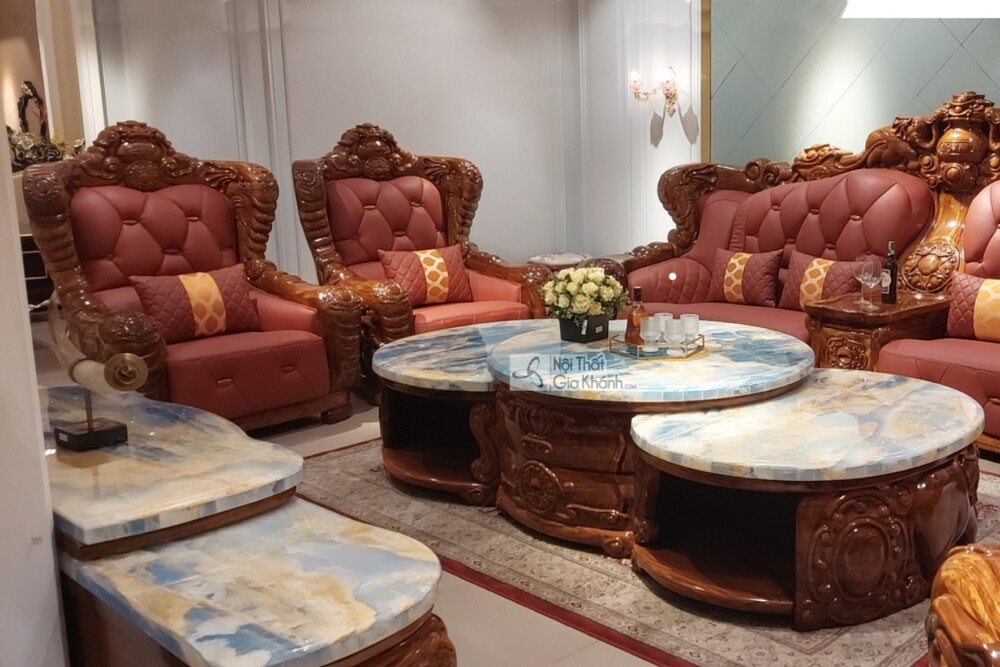 Góc chụp chéo từ phía trước, làm nổi bật sự đối xứng và hoành tráng của bộ sofa gỗ mun. Các ghế đơn và băng ghế dài được b…