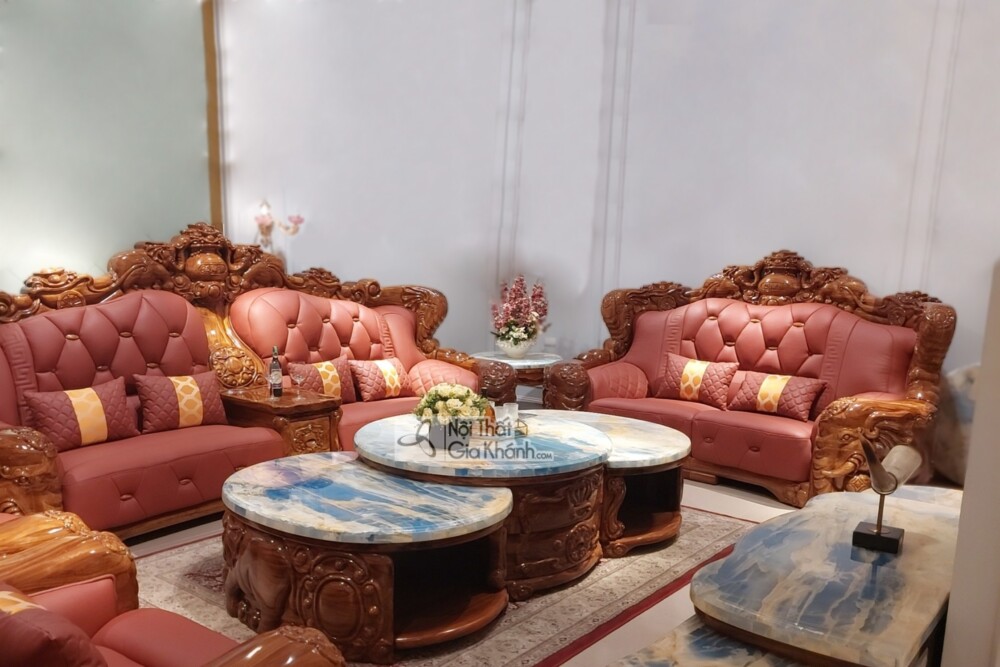 Cận cảnh bộ sofa gỗ mun và bàn trà chính, góc chụp ngang tầm mắt. Ghế sofa bọc da màu nâu đỏ, tựa lưng cao với các đường n…