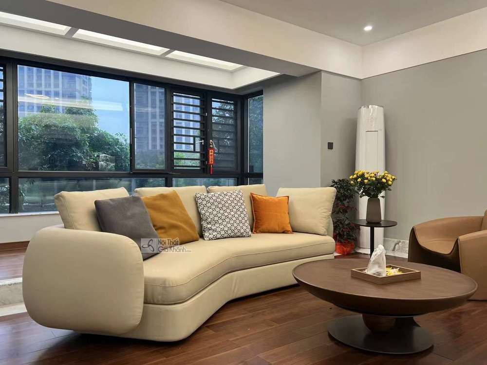 Sofa cong SF2112 màu kem nhạt, bọc da, được đặt trong không gian phòng khách hiện đại. Ghế có thiết kế uốn lượn mềm mại, t…