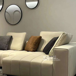 Cận cảnh phần góc trái của bộ sofa SF2201, bọc da thật màu kem nhạt. Đệm ngồi và tựa lưng dày dặn với đường may dọc tạo đi…