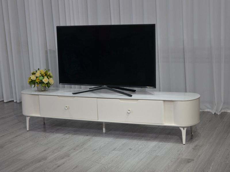 Kệ tivi cố định mặt đá KTPL2316B-20 màu trắng kem, chụp từ góc chếch phía trước bên trái. Kệ có thiết kế hiện đại với mặt…