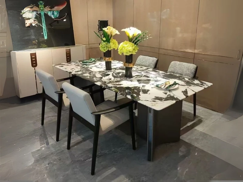 Bàn ăn mặt đá cẩm thạch tự nhiên 2m4 BAQ55-24 được chụp từ góc hơi chếch, cho thấy rõ mặt bàn vân đá trắng đen độc đáo và…