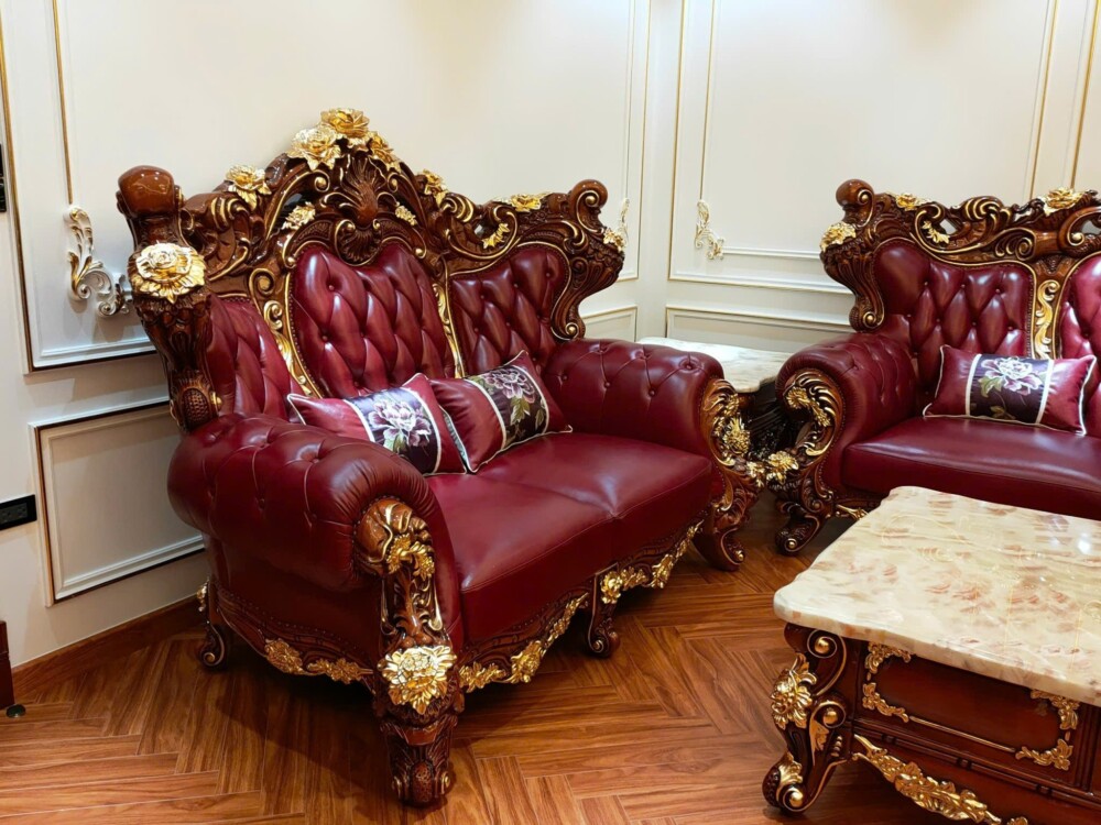 Cận cảnh sofa băng 2 của bộ SB926-124, bọc da màu đỏ đô với các đường may rút múi tinh tế ở lưng ghế. Khung gỗ tự nhiên đư…