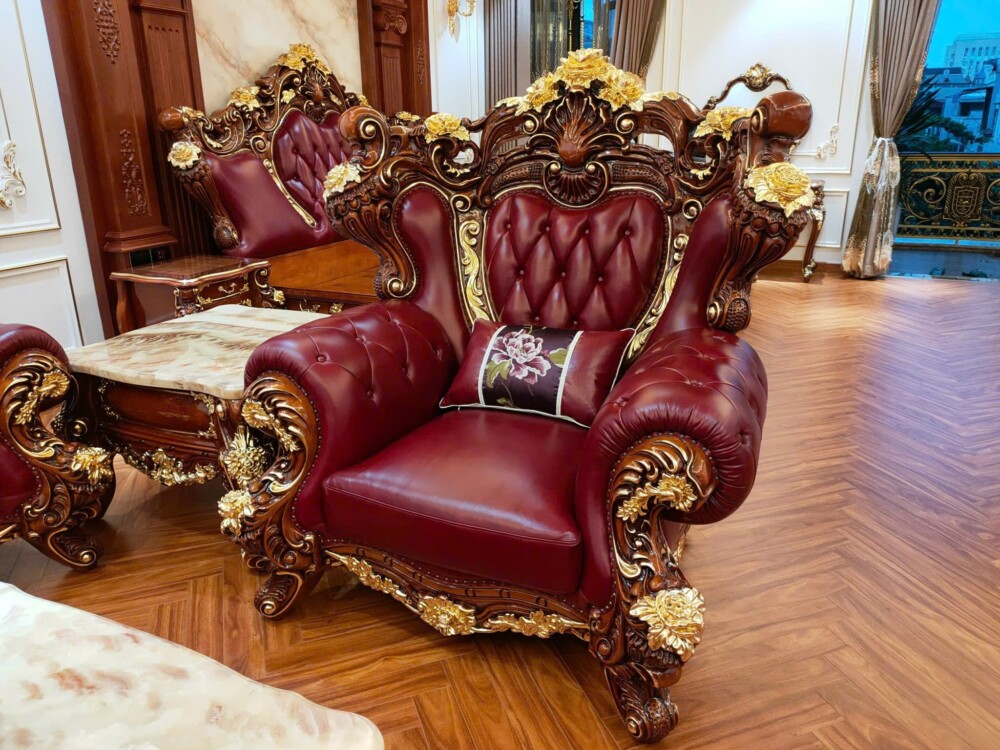 Chi tiết ghế sofa đơn của bộ SB926-124, nổi bật với phần lưng ghế cao, bọc da đỏ đô và tựa lưng rút múi. Tay vịn và chân g…
