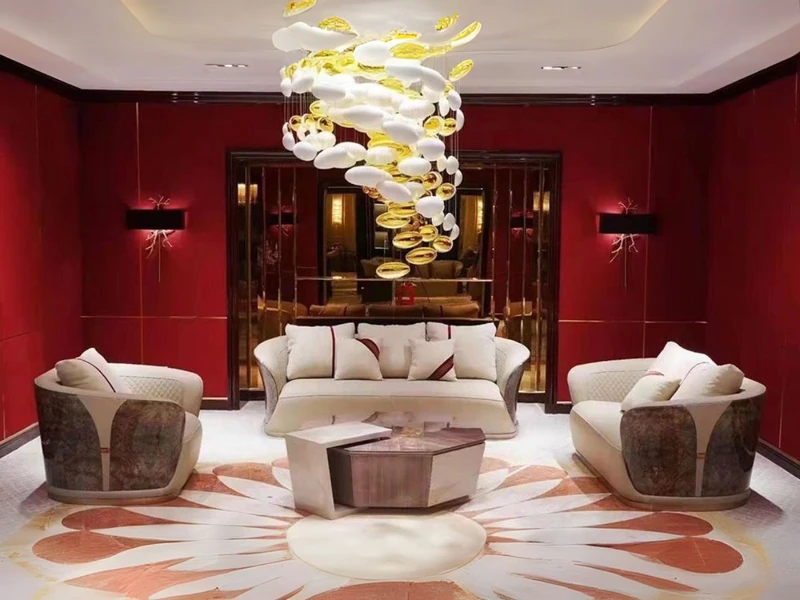 Bộ sofa luxury SBGD23-123 gồm một ghế băng dài và hai ghế đơn bọc da màu kem, đặt trong phòng khách tông đỏ đô. Ghế đơn có…