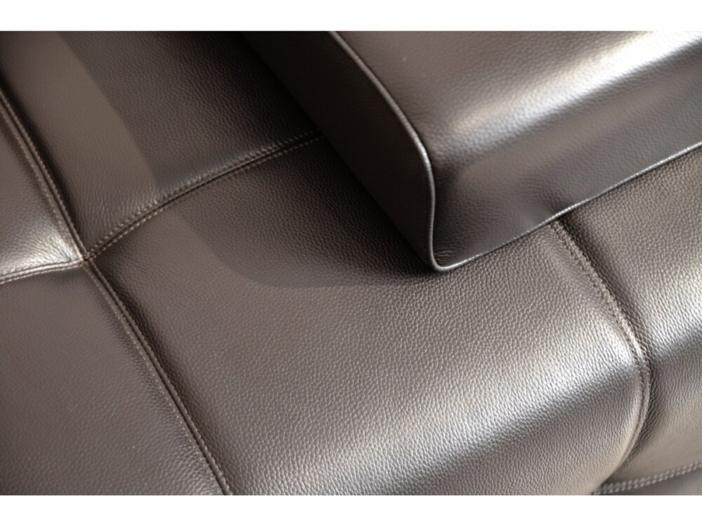 Cận cảnh chi tiết bề mặt da bò thật của sofa SF-HY01. Da có vân tự nhiên, màu đen sẫm, với đường viền chỉ trắng nổi bật ở…