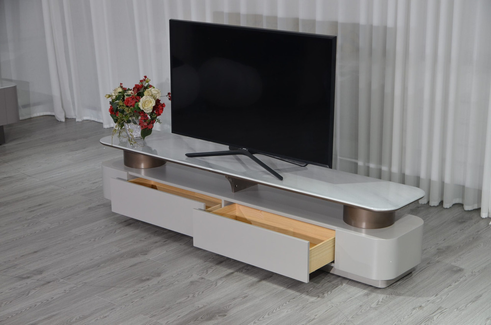 Kệ tivi KTKD8630-20 được trưng bày trong một không gian phòng với rèm cửa trắng và sàn gỗ màu xám. Một ngăn kéo của kệ đượ…