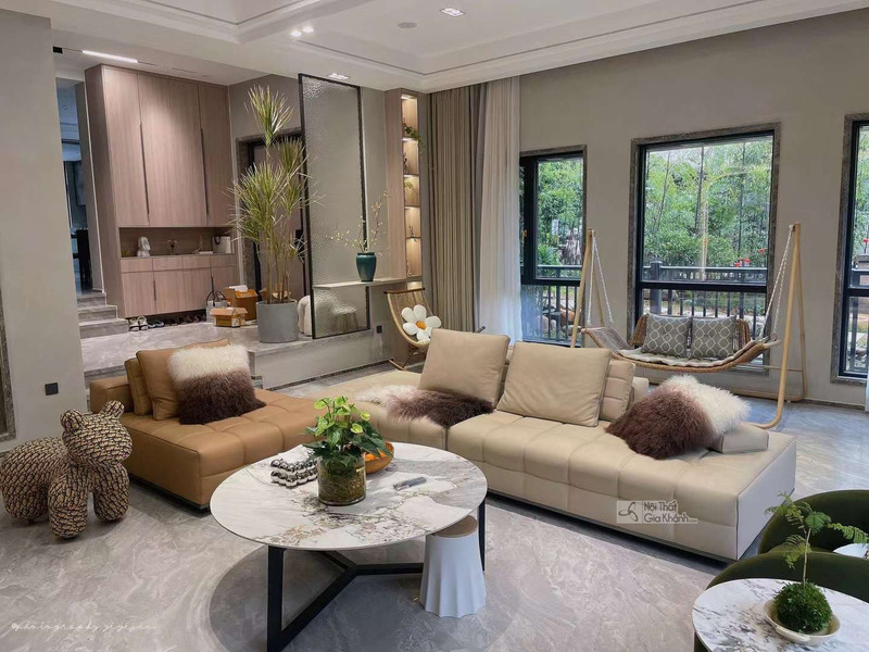 Bộ sofa góc hiện đại SF2216 được chụp từ góc rộng, đặt trong không gian phòng khách sang trọng với cửa sổ lớn nhìn ra cây…