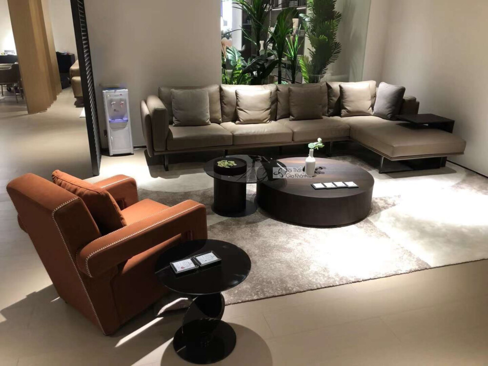 Toàn cảnh không gian phòng khách trưng bày bộ sofa góc trái SF0064GT màu xám ghi, chụp từ góc rộng hơn, có thêm ghế đơn mà…