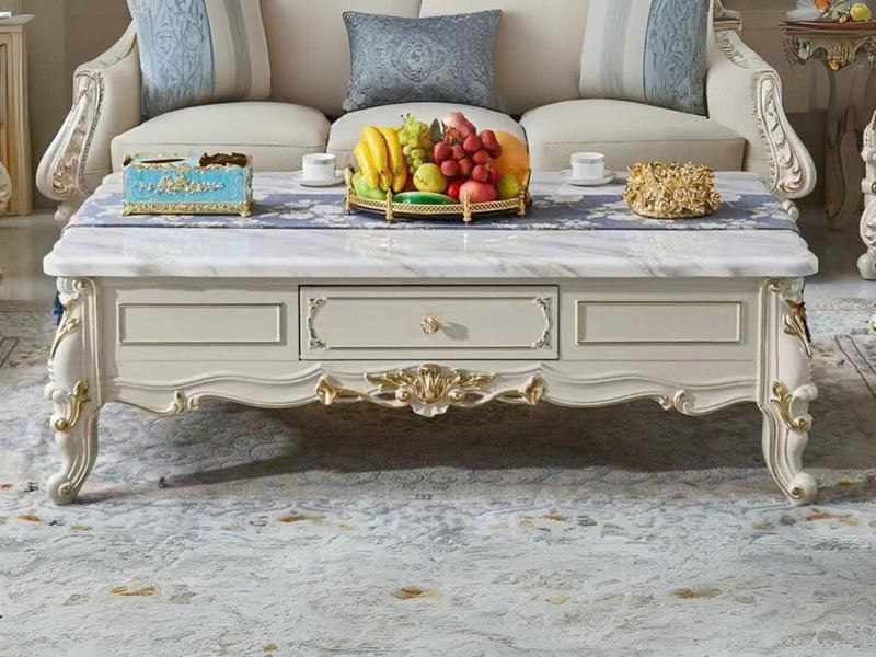 Bàn trà tân cổ điển BTA20-15 chụp chính diện, đặt trong không gian phòng khách sang trọng với ghế sofa màu kem. Bàn có mặt…
